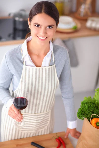 Mooie vrouw die thuis wat wijn drinkt in de keuken — Stockfoto