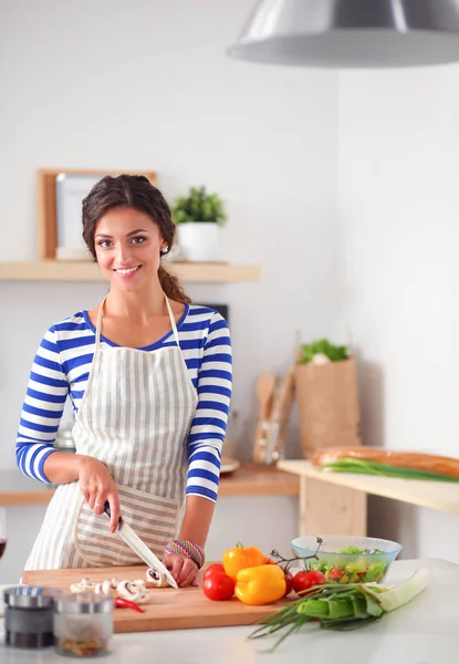 Giovane donna che taglia verdure in cucina a casa — Foto Stock