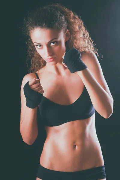 Портрет молодой красивой фитнес-женщины, изолированной на черном фоне — стоковое фото