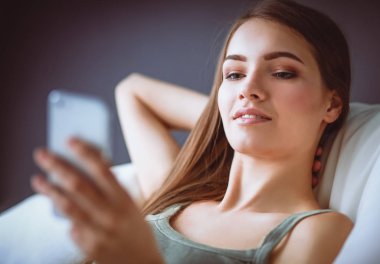 güzel bir kadın onun oturma odasında kanepede karışıklık gönderme yalan