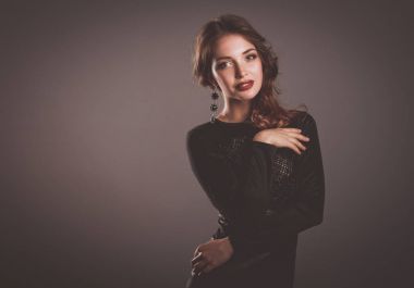 Siyah elbiseli, akşam makyajlı güzel bir kadın.