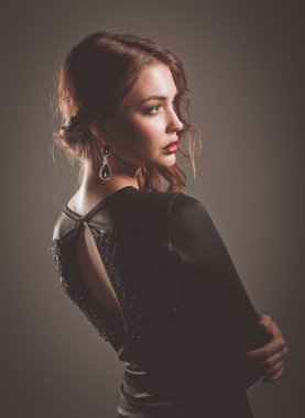 Siyah elbiseli, akşam makyajlı güzel bir kadın.