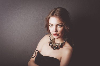 Siyah elbiseli, akşam makyajlı güzel bir kadın.