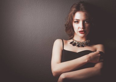 Siyah elbiseli, akşam makyajlı güzel bir kadın.