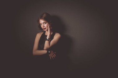 Siyah elbiseli, akşam makyajlı güzel bir kadın.