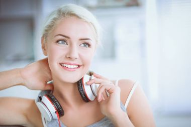 Evdeki genç ve güzel kadın kanepede oturup müzik dinliyor.