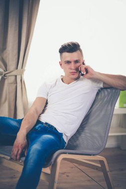 Genç işadamı ofiste çalışıyor, masada oturuyor.