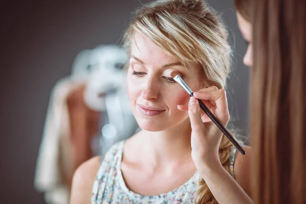 Konstnär gör professionell make up av kvinna — Stockfoto