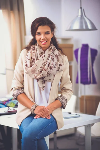 Sorrindo designer de moda feminina sentado na mesa de escritório — Fotografia de Stock