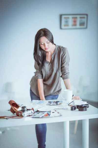 Kvinna sitter på en soffa i hennes hus med kamera — Stockfoto