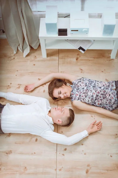 Feliz pareja joven acostados juntos en el suelo —  Fotos de Stock
