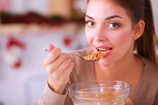 Leende attraktiv kvinna som äter frukost i köket interiör — Stockfoto