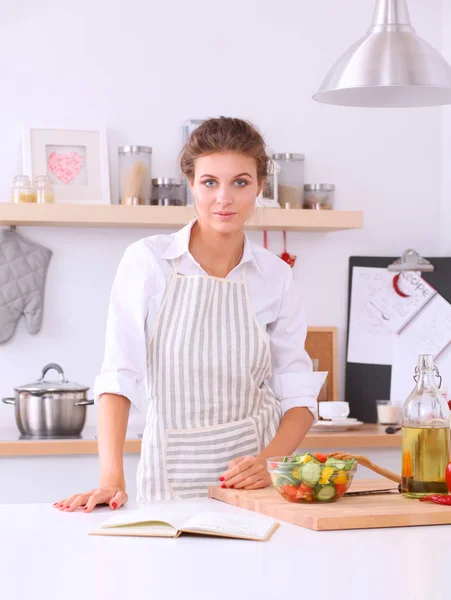 Uśmiechnięta młoda kobieta stojąca w kuchni — Zdjęcie stockowe