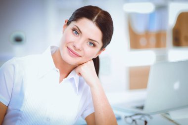 Ofiste masa başında oturan çekici bir iş kadını.