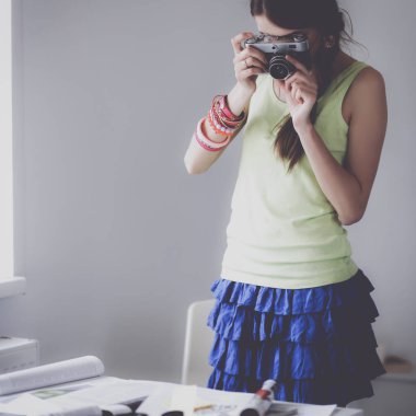 Masanın yanında genç ve güzel bir fotoğrafçının portresi.