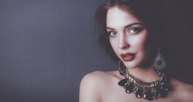 Siyah elbiseli, akşam makyajlı güzel bir kadın.