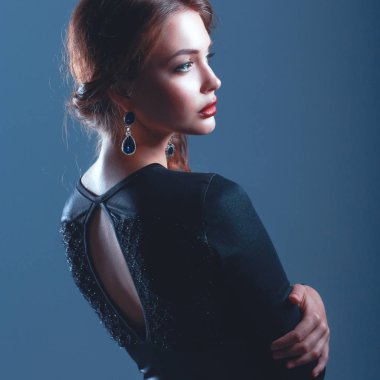 Siyah elbiseli, akşam makyajlı güzel bir kadın.