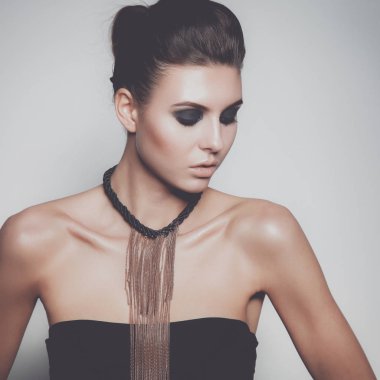 Gri arka plan üzerinde duran güzel genç kadın