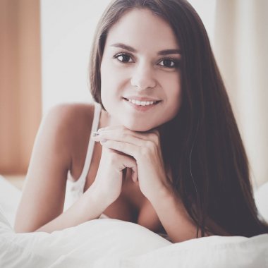 Evdeki yatakta uzanmış güzel esmer