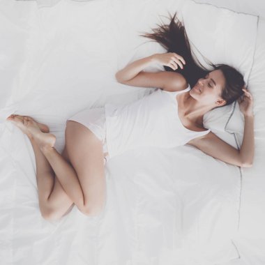 Evde yatakta yatan genç güzel kadın