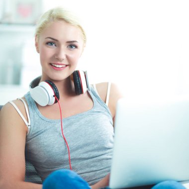 Evdeki genç ve güzel kadın kanepede oturup müzik dinliyor.