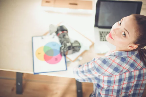 Kvinnlig fotograf sitter på skrivbordet med bärbar dator — Stockfoto