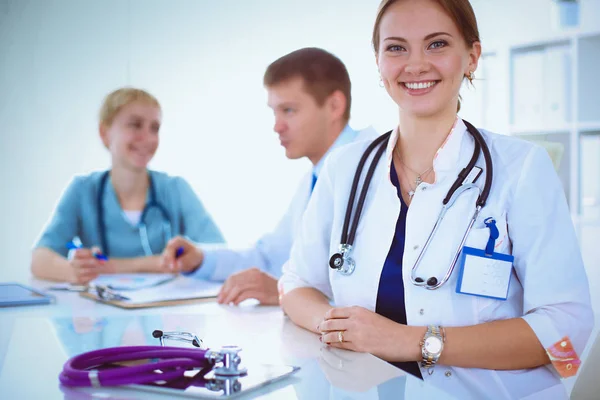 Attractive female doctor in front of medical group — Stock Photo, Image