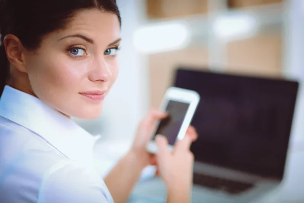 Affärskvinna skicka meddelande med smartphone sitter på kontoret — Stockfoto