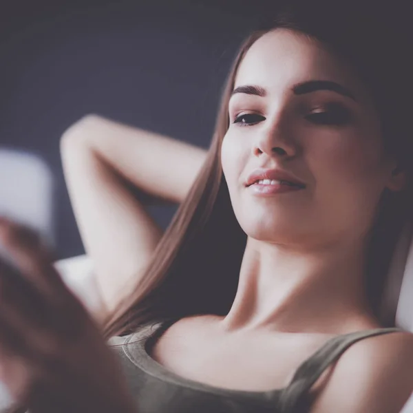 Pretty woman in her living room lying on the couch sending mess — Stock Photo, Image