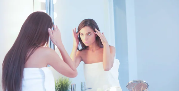 Attrayant jeune femme appliquant de la crème sur son visage — Photo