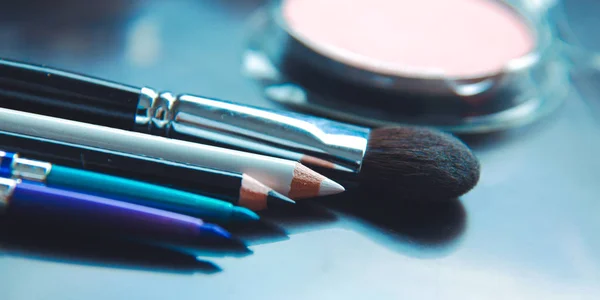 Pinceles de maquillaje y sombras de maquillaje en el escritorio —  Fotos de Stock