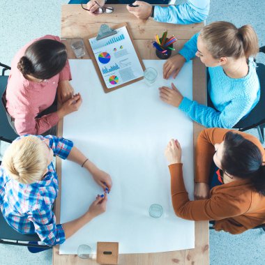 İş adamları iş toplantısında, ofiste oturup tartışıyorlar.