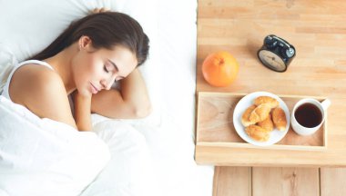 Evde yatakta yatan genç güzel kadın