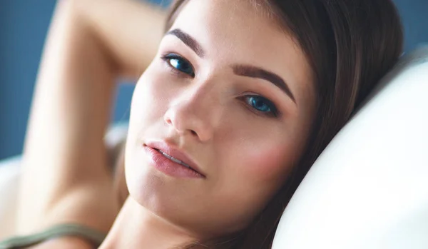Closeup of a smiling young woman lying on couch — Stock Photo, Image