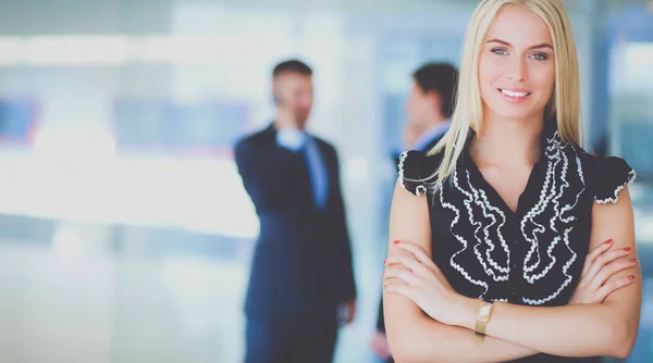 Affärskvinna som står i förgrunden i office — Stockfoto