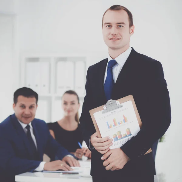 Porträtt av en vacker affärsman står i office med kollegor — Stockfoto