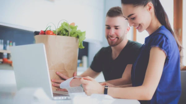 Paret betalar sina räkningar med laptop i köket hemma — Stockfoto