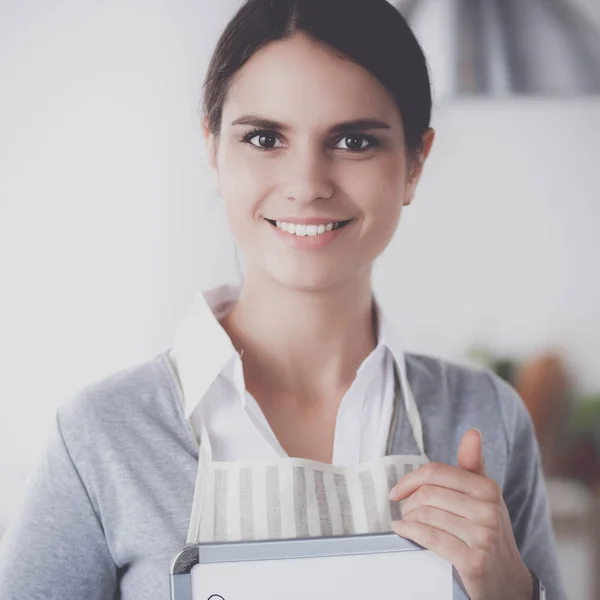 Donna in cucina a casa, in piedi vicino alla scrivania con cartella — Foto Stock