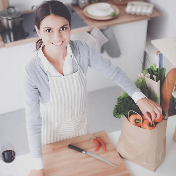 Mujer haciendo comida saludable de pie sonriendo en la cocina — Foto de Stock