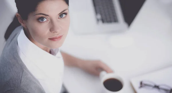 Attraktive Geschäftsfrau sitzt auf Schreibtisch im Büro — Stockfoto