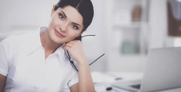 Attraktive Geschäftsfrau sitzt auf Schreibtisch im Büro — Stockfoto