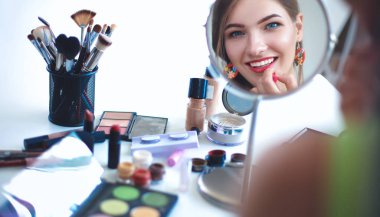 Genç güzel kadın ayna, Masa başında oturan yakınındaki makyaj yapma