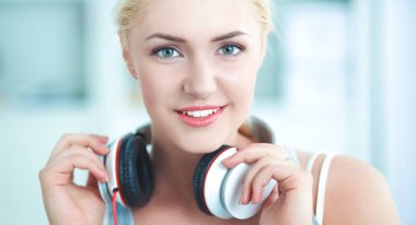 Evdeki genç ve güzel kadın kanepede oturup müzik dinliyor.
