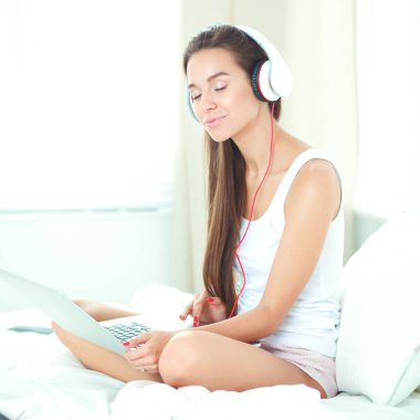 Genç güzel kadın yatakta müzik