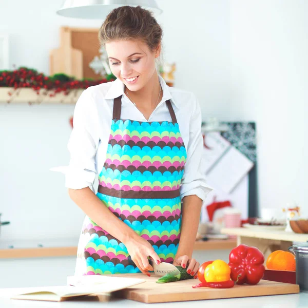 Jonge mooie vrouw snijden groenten in de keuken — Stockfoto