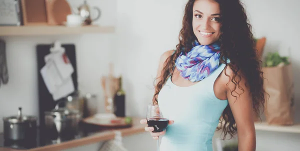 Mujer bonita bebiendo un poco de vino en casa en la cocina —  Fotos de Stock