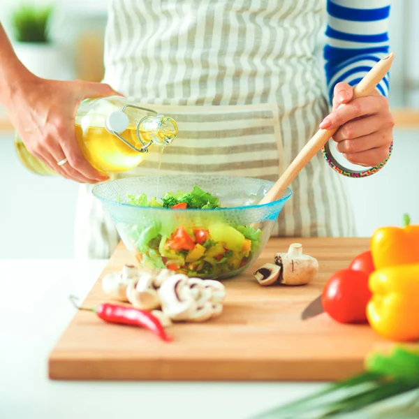 Mujer joven mezclando ensalada fresca — Foto de Stock