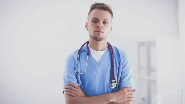 Arzt mit Stethoskop stehend, verschränkte Arme, isoliert auf weißem Hintergrund — Stockfoto