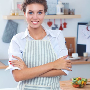 Mutfakta yemek kitabı okuyan genç bir kadın yemek tarifi arıyor.