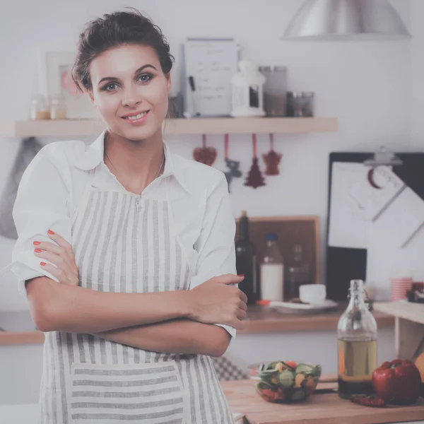 Lächelnde junge Frau steht in der Küche — Stockfoto